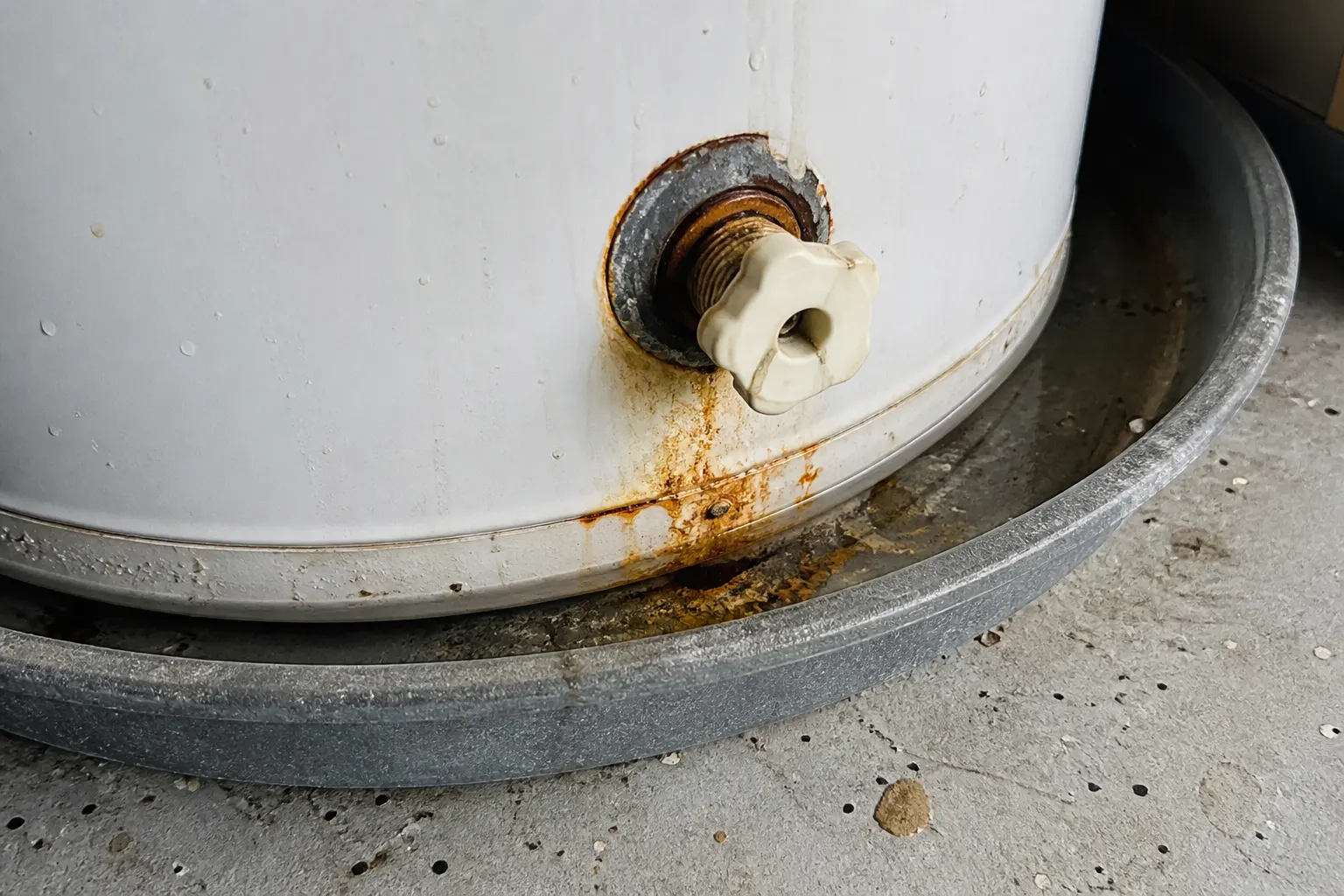 Sediment from Tampa hard water in a heater drain pan